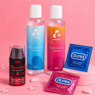 Färgglada glidmedel, stimulerande gel och kondomer arrangerade på rosa bakgrund. Produkter för intimvård, säkrare sex och ökad njutning.