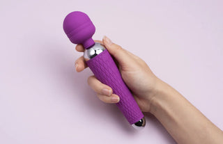 Hand som håller i lila magic wand vibrator